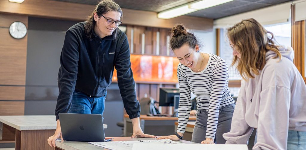 Un monde d'opportunités Photo de trois personnes penchées au-dessus d'une table regardant un plan