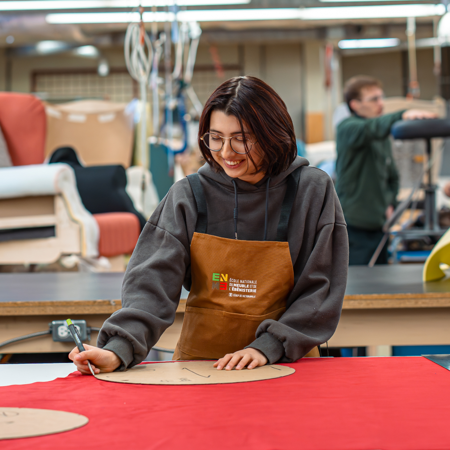 Photo d'une élève taillant du matériel sur une table de travail