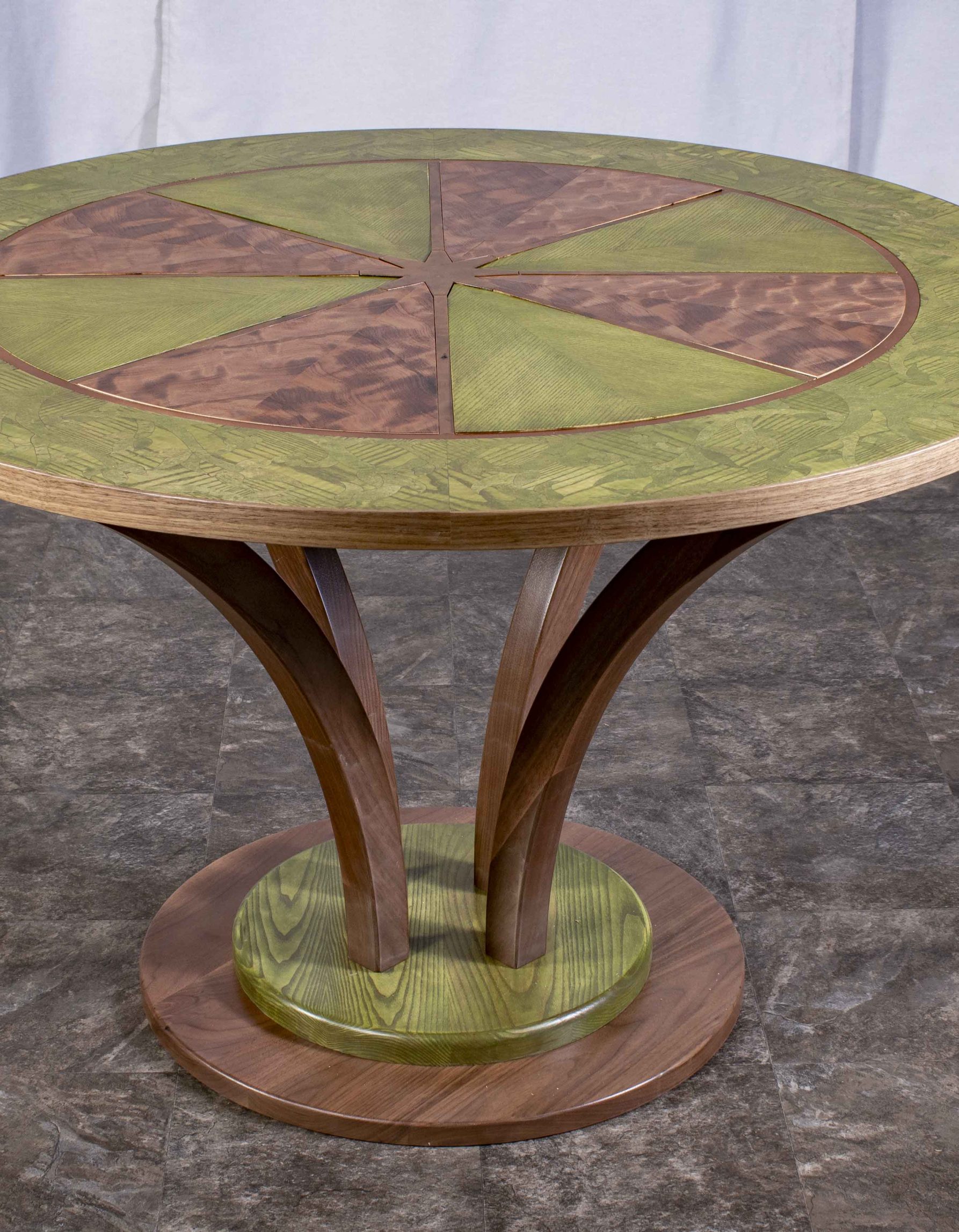 Photo de la table ronde fabriquée par Benjamin Roof avec des tons de brun et vert