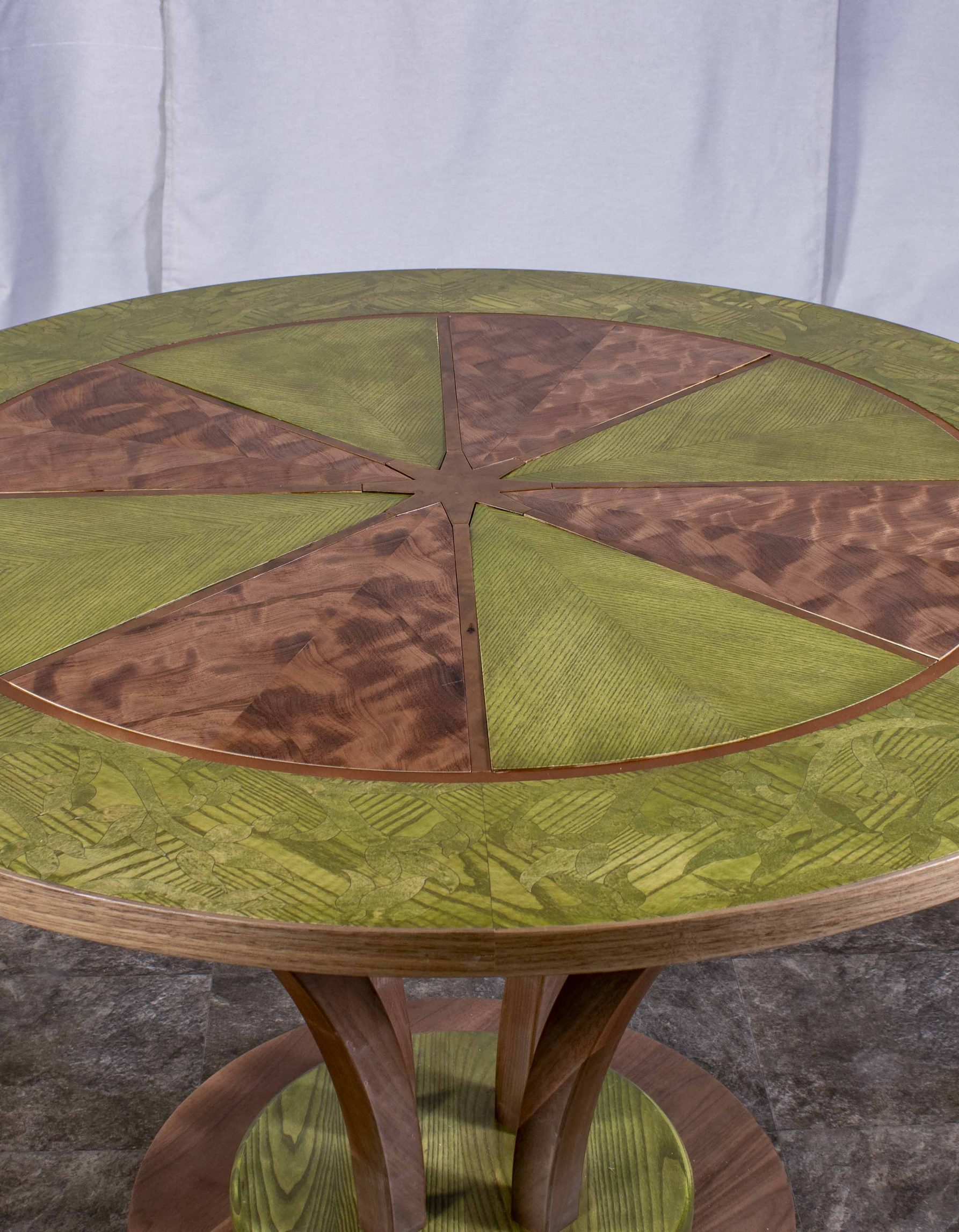 Photo de la table ronde fabriquée par Benjamin Roof avec des tons de brun et vert