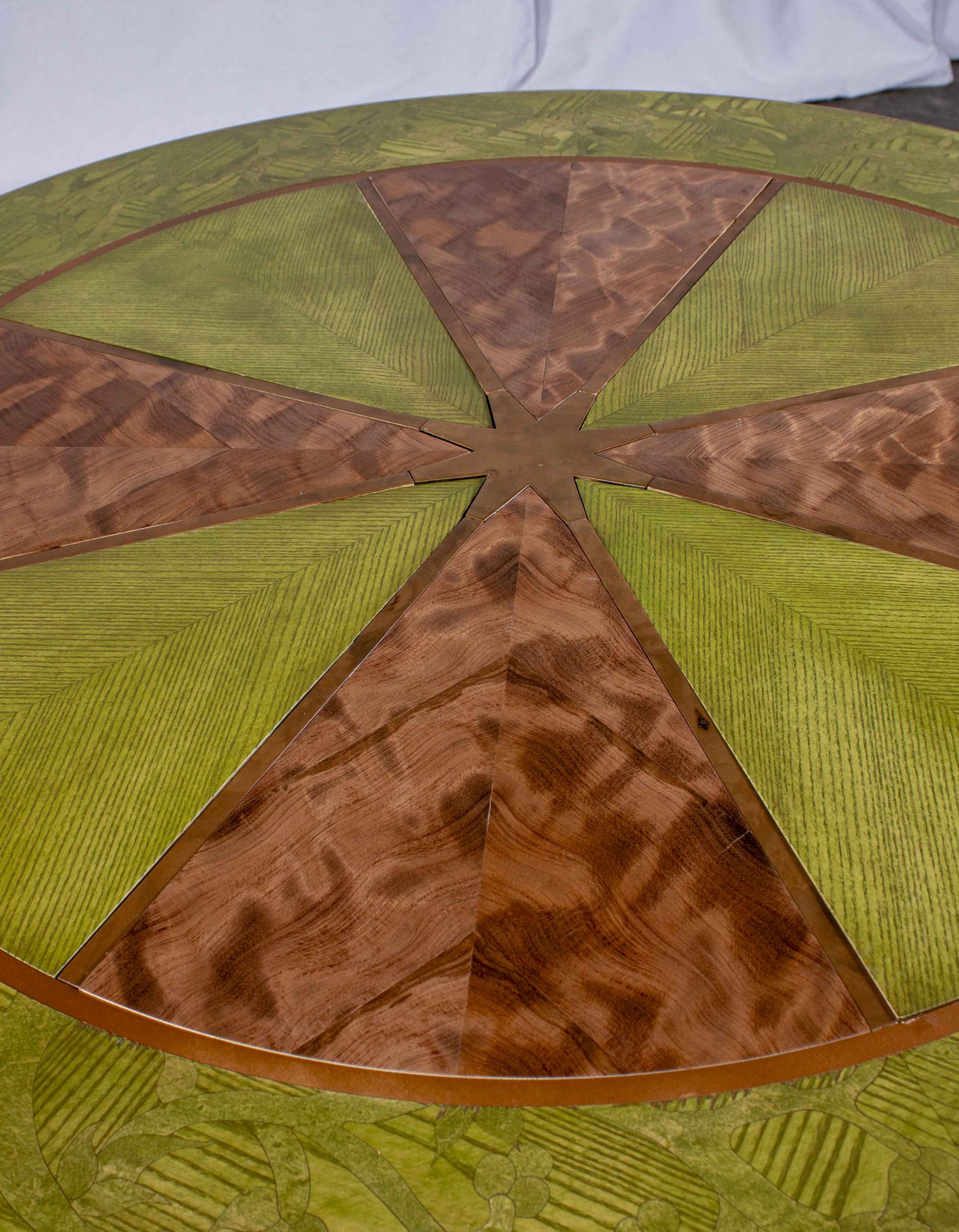 Gros plan du dessus de la table ronde fabriquée par Benjamin Roof avec des tons de brun et vert