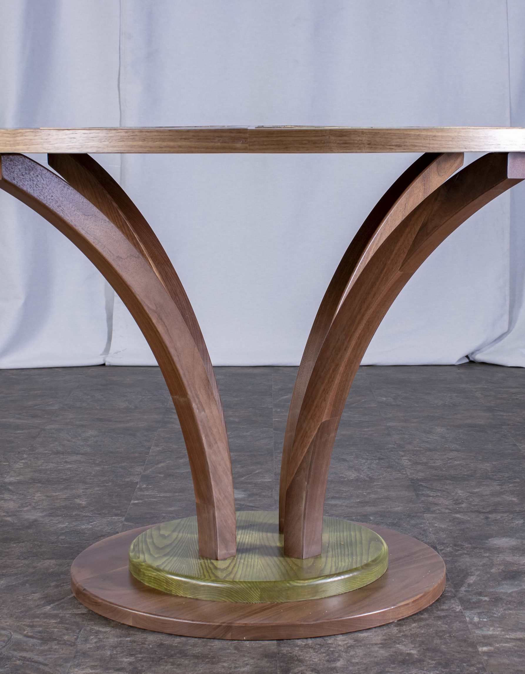 Photo du dessous de la table ronde fabriquée par Benjamin Roof avec des tons de brun et vert