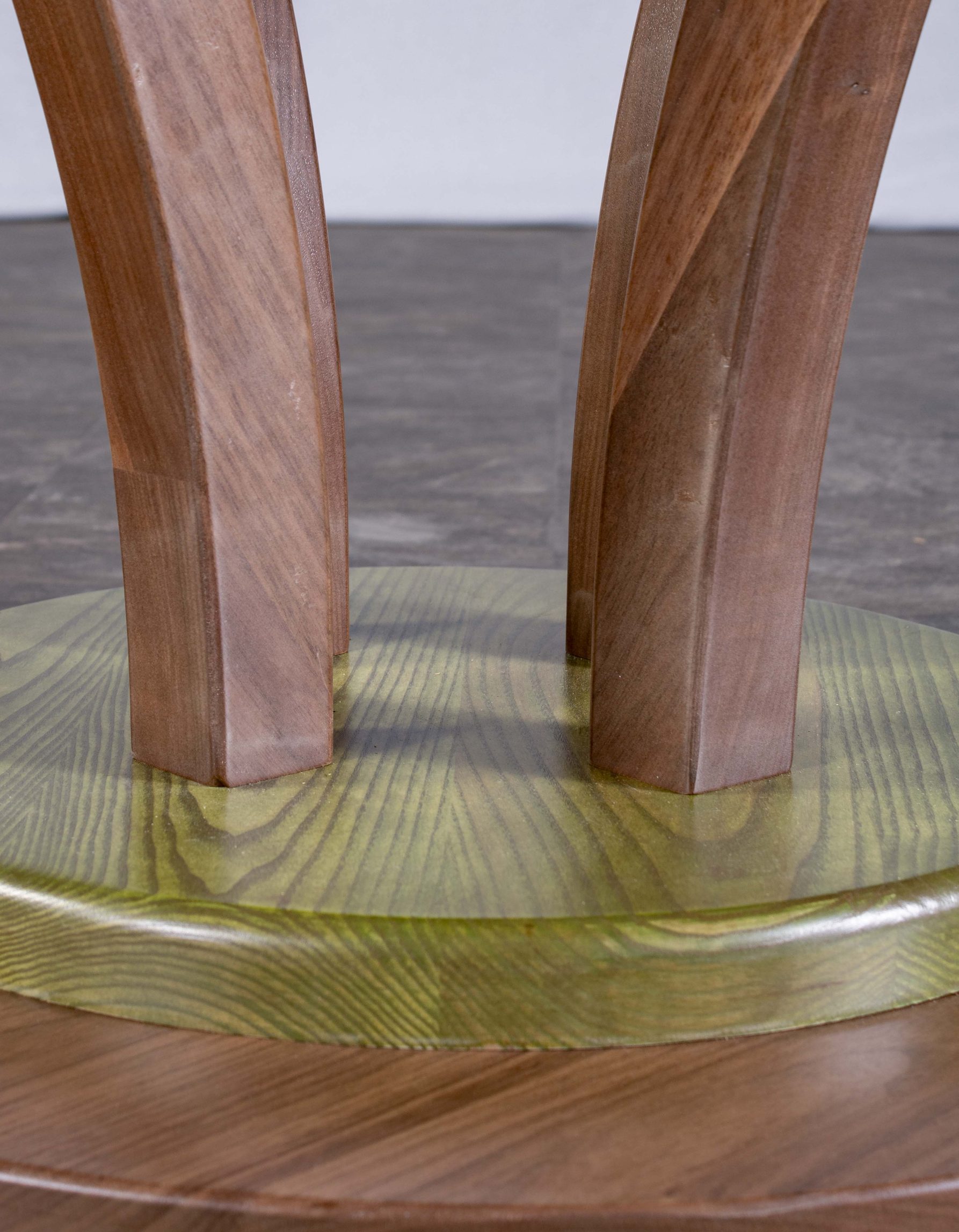 Photo du pied de la table ronde fabriquée par Benjamin Roof avec des tons de brun et vert