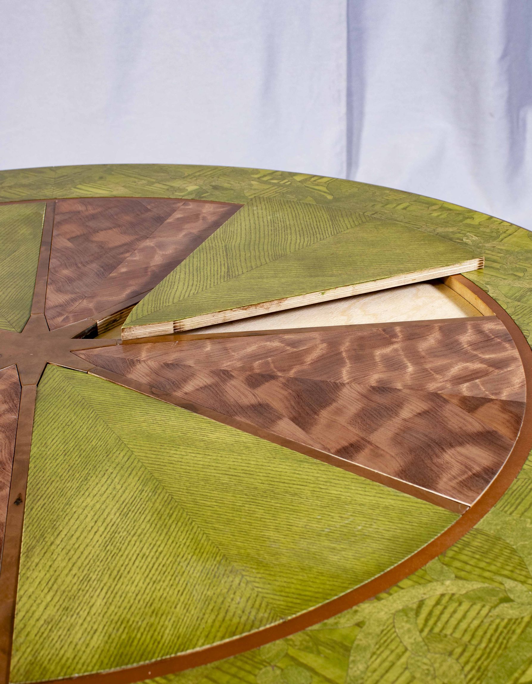 Gros plan du dessus de la table ronde fabriquée par Benjamin Roof avec des tons de brun et vert