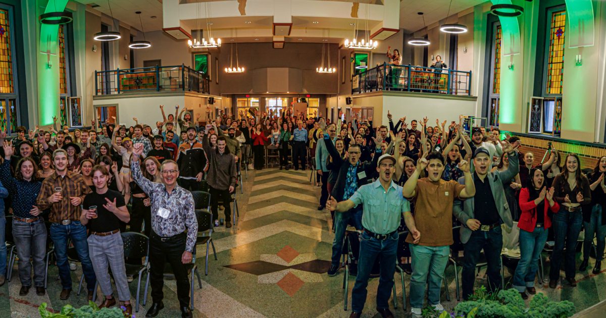 photo prise de la scène, on y voit tous les invités debout, les bras dans les airs souriants