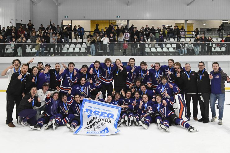 Photo d'équipe montrant les joueurs des Vulkins hockey qui célèbrent avec la bannière de champions provinciaux 2025-2026