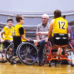 équipe de basketball en fauteuil roulant, athètes avec dossard jaune et un arbitre