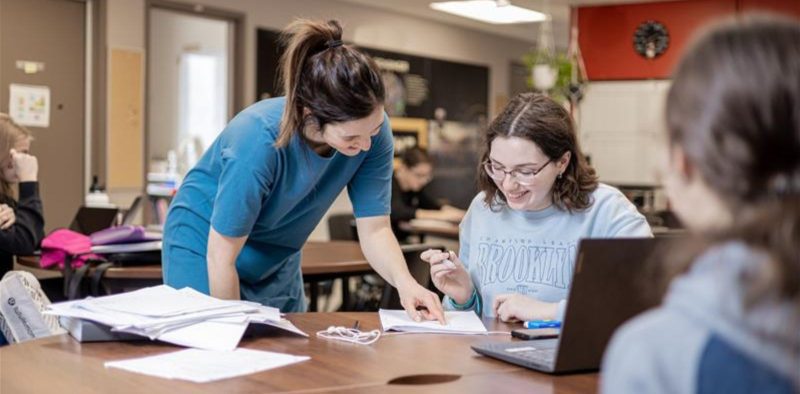 photo d'une prof avec deux élèves à une table de travail