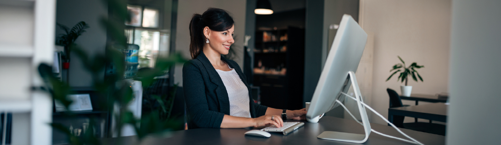 Femme assise devant un écran d'ordinateur